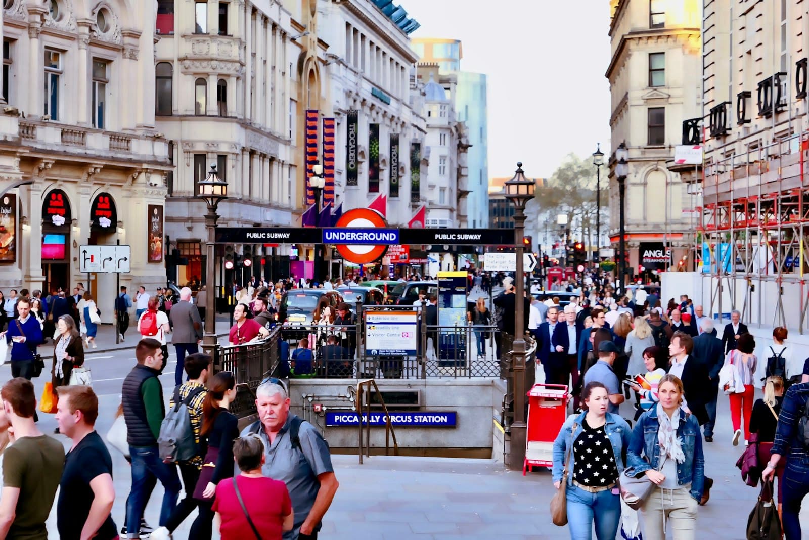 People walking along a busy pavement near Piccadilly Circus in London