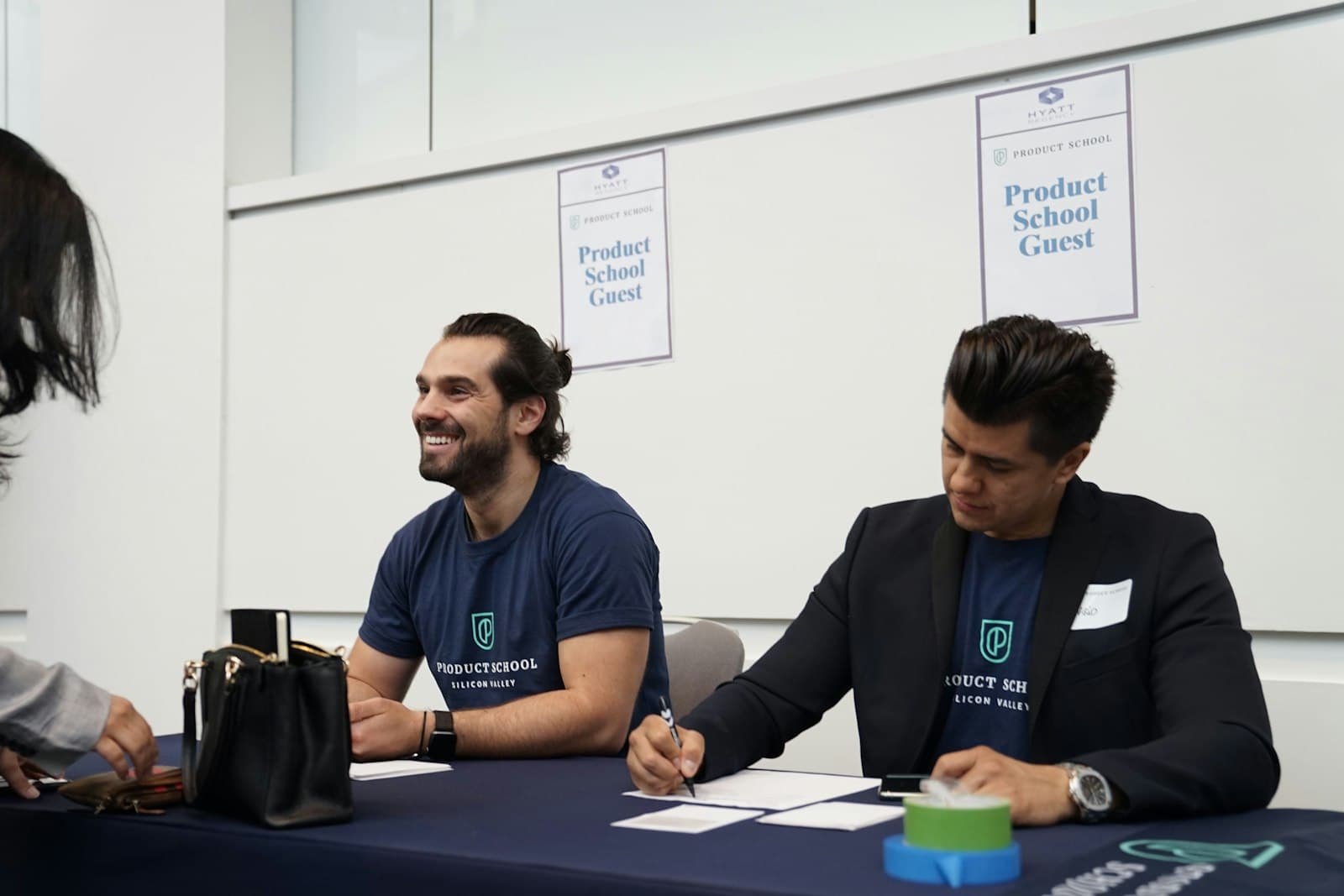 Two people at a registration table with name badges laid out in front of them